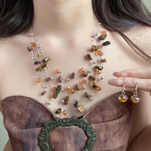 Detail of a vintage tiger eye stone multi-layered necklace and earrings jewelry set