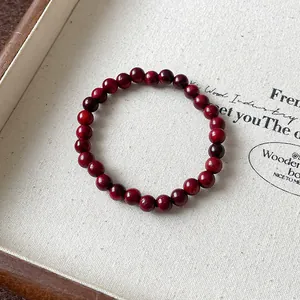 Detaillierte Makroansicht eines dunkelroten Holzperlenarmbands auf einem Canvas-Tablett
