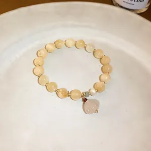 Detailed view of a New Chinese style beaded bracelet with a delicate pale pink flower charm
