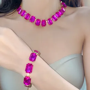 Nahaufnahme einer Halskette und eines Armbands mit magentafarbenem Kristall