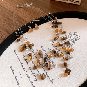 Close-up of a vintage multi-layer tiger eye bead necklace and earring set on a mat