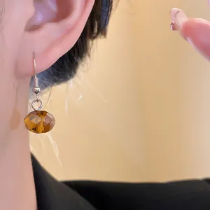 Close-up detail of a vintage brown faceted crystal bead earring worn on a model's ear