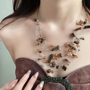 Close-up of a vintage multi-layer tiger eye and amber bead necklace on model