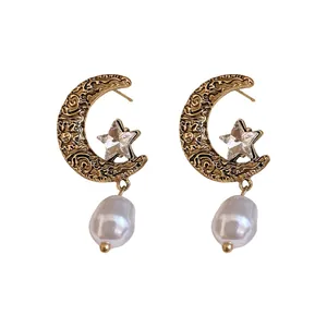 Vintage French style moon and star earrings with faux pearl drops on white background