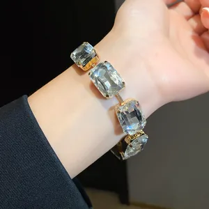 Detailansicht eines eleganten Armbands mit großen Kristallen im Smaragdschliff in Goldfassung