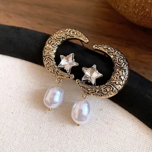 Detailed close-up view of French retro style moon and star pearl earrings with golden finish