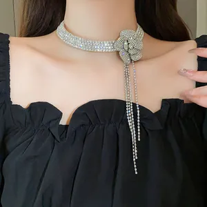 Detailed view of a sparkling rhinestone flower tassel choker necklace on a model