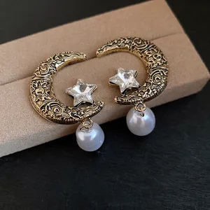 Vintage French style moon and star earrings with pearls and crystals macro view