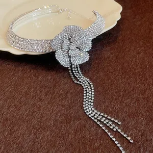 Close-up of elegant silver rhinestone flower choker necklace with long tassels on a plate