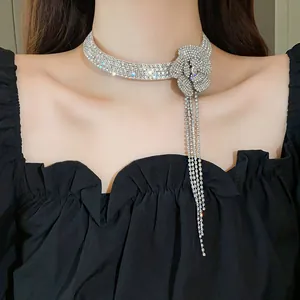 Close-up of a sparkling rhinestone flower choker necklace with long tassels on a model.