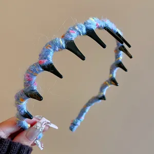 Close-up of blue woolen yarn wrapped wave headband with black teeth for volume