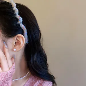 Detail view of a colorful woolen yarn wrapped wavy headband styled on black hair