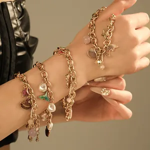 Macro view of ocean-themed gold chain bracelet with seashell, star and pearl charms