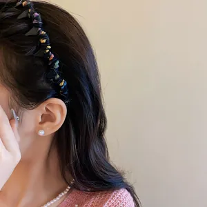 Close-up detail of a colorful yarn-wrapped wavy headband worn by a model in autumn style