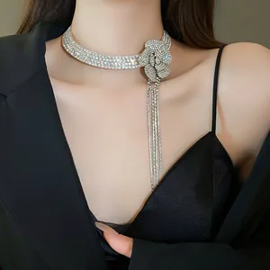 Detail view of an elegant silver rhinestone flower choker featuring long dangling tassels