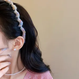 Detailed view of a sweet wool-wrapped wave headband worn on long wavy dark hair