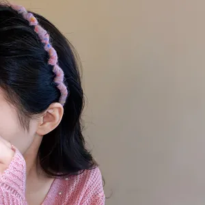 Detail of pink knitted wavy headband showing soft yarn texture and volumizing style.