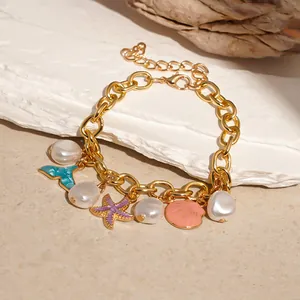 Macro view of ocean theme gold charm bracelet with pearls, starfish, and colorful shell pendants.