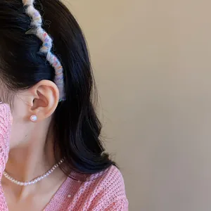 Detail view of a wavy yarn-wrapped headband on an Asian model with sweet fashion style.
