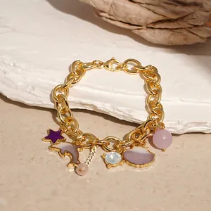 Detail of gold chunky link bracelet with ocean-themed starfish and seashell charms.