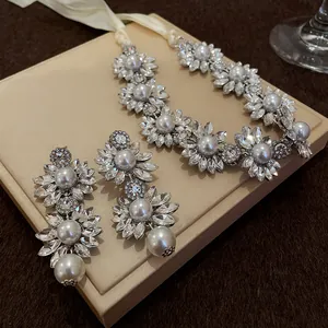 Close-up of crystal flower and pearl statement necklace and matching earrings set