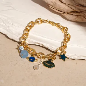 Detailed macro view of a gold chain bracelet featuring marine star and shell charms