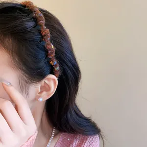 Detailed view of a brown wool wrapped wavy headband worn by a model for a sweet look