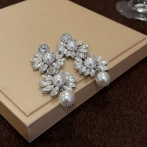 Detail view of elegant crystal and pearl flower-shaped drop earrings for stylish women