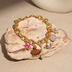 Detail view of ocean themed charm bracelet with gold chain and colorful shell charms