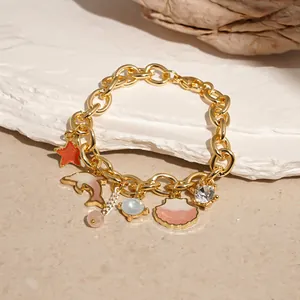 Detailed view of ocean-themed gold charm bracelet with shell and starfish pendant