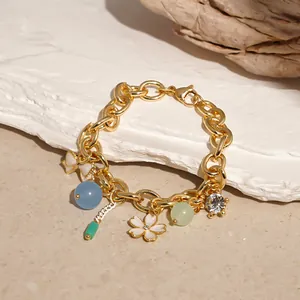 Detail view of an ocean-themed charm bracelet with enamel flowers and crystals.