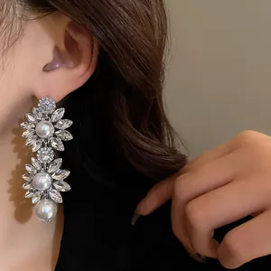 Detailed view of vintage crystal flower drop earrings with white pearls for elegant look