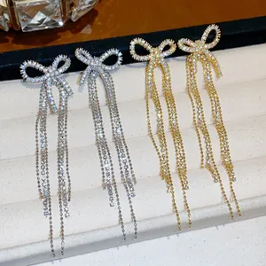 Detailed close-up of luxury 18k gold plated zircon bow earrings with long tassels