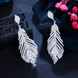 Close-up of elegant silver feather earrings with pavé cubic zirconia crystals
