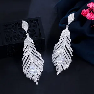 Close-up of sparkling zircon feather earrings with large pear-shaped center stone