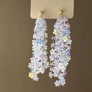 Detalle de los pendientes de borla con flores de lentejuelas y diseño en cascada.