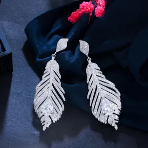 Detailed view of elegant feather-shaped earrings with sparkling cubic zirconia stones.