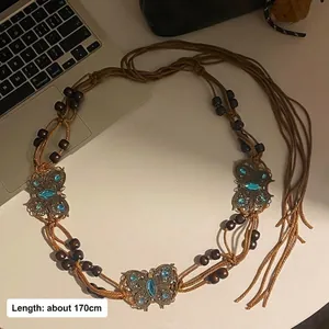 Detailansicht der böhmischen Taillenkette aus geflochtenem Seil mit Holzperlen und Schmetterlingen