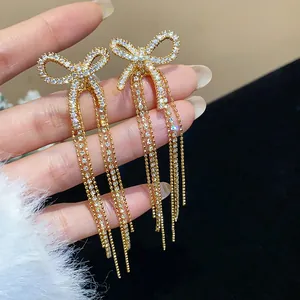 Close-up detail of luxury zircon paved bow-knot tassel earrings with gold plating finish