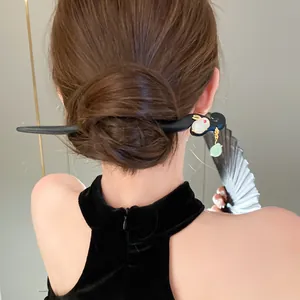 Dettaglio di un elegante fermaglio per capelli stile cinese con coniglio e nappa verde
