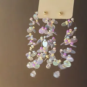 Detailed view of iridescent sequin flower tassel earrings with colorful seed beads