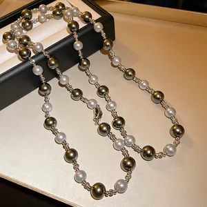 Macro detail of French vintage pearl necklace with grey and green beads and silver rings