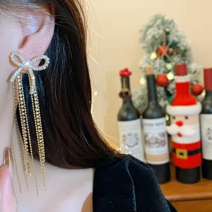 Elegant zircon bow tassel earrings with 18k gold plating worn for a festive Christmas look