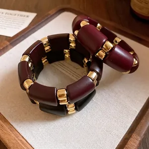 Elegante conjunto de pulseras de acrílico granate y negro con detalles dorados