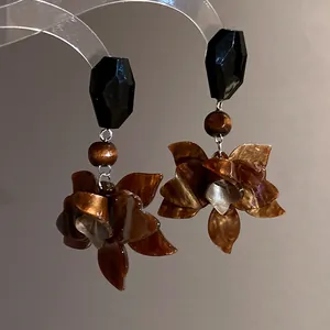 Detailed macro view of vintage brown resin flower dangle earrings in Maillard style decor