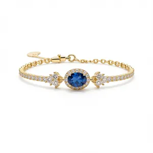 Elegante bracciale d'oro con zircone ovale blu e pietre bianche, stile francese minimal.