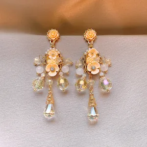 Elegantes pendientes largos de flores albaricoque con borlas de cristales facetados claros