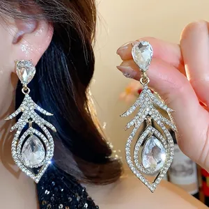 Vintage crystal hollow feather drop earrings with silver needles for elegant party wear.