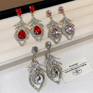 Vintage gold hollow feather earrings with teardrop crystals in red, pink, and clear