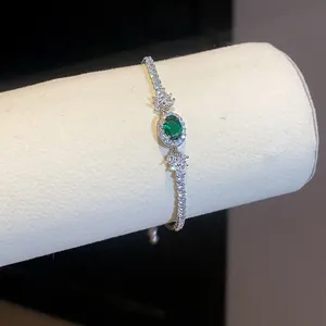Vista dettagliata di un elegante bracciale in argento con uno zircone verde ovale centrale